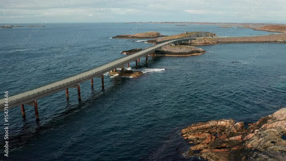Magnificent stretch of Atlantic ocean road with long bridge gracefully spanning deep blue waters. Rough waves crash near rugged coastline in Norway Magnificent stretch of Atlantic ocean road with long bridge gracefully spanning deep blue waters. Rough waves crash near rugged coastline in Norway