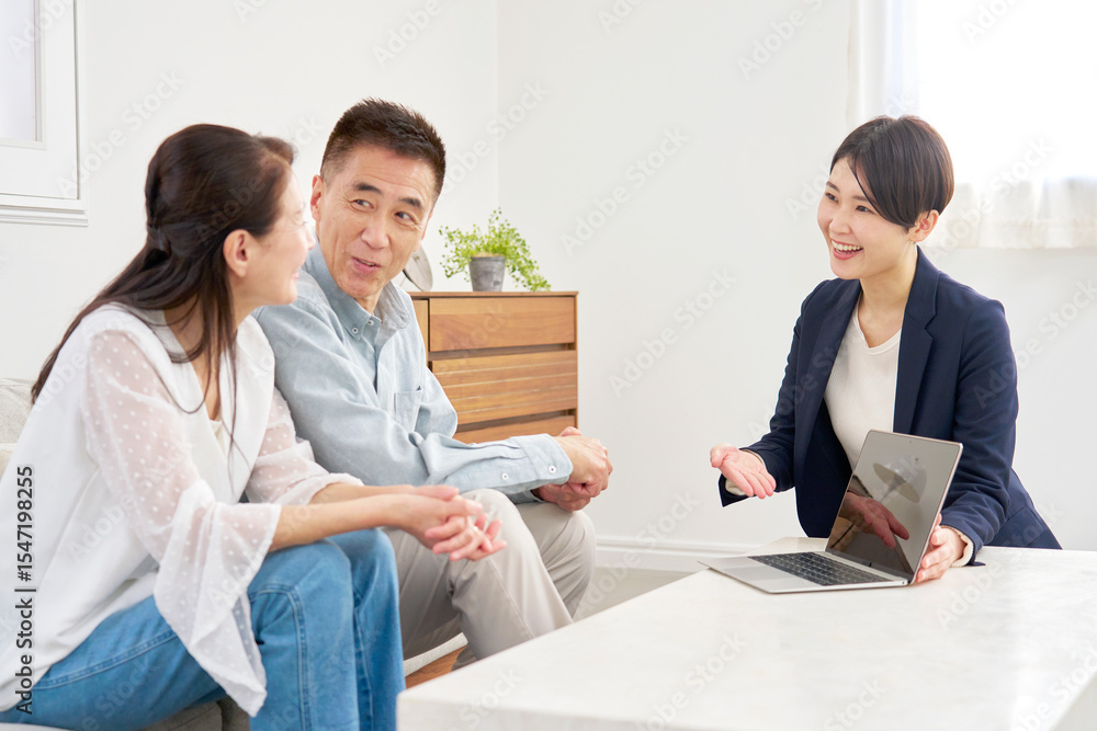 Obraz premium セールスレディと会話するシニア夫婦 リビング