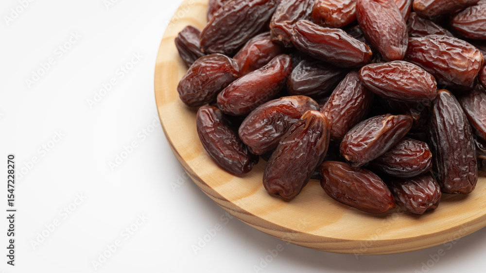 Dried dates on a round wooden board. Food, sweets, a copy of the space. Dried dates on a round wooden board. Food, sweets, a copy of the space.