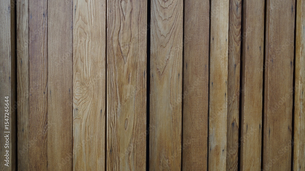 Naklejka premium Wooden fence, background of the wall made of wooden texture. Background with wooden beams. Interior of a village wooden house with vertical logs. Texture of tree trunks of different widths