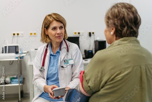 Photos Elderly female patient undergoing blood pressure test at routine check-up