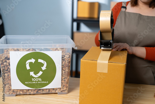 A woman using kraft paper tape to seal a cardboard box in a home-based business, highlighting eco-friendly packaging and sustainable practices in small business operations