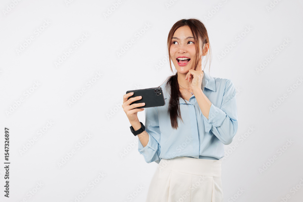 Happy young Asian woman holding a smart mobile phone thinks about something, looking thoughtfully. She might question a problem or think of a solution. isolated studio white background Happy young Asian woman holding a smart mobile phone thinks about something, looking thoughtfully. She might question a problem or think of a solution. isolated studio white background