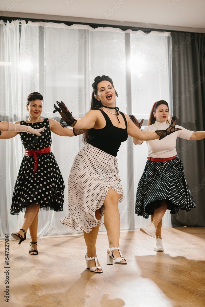 Naklejka premium Women wearing polka dot dresses and black gloves dancing in 1950s style