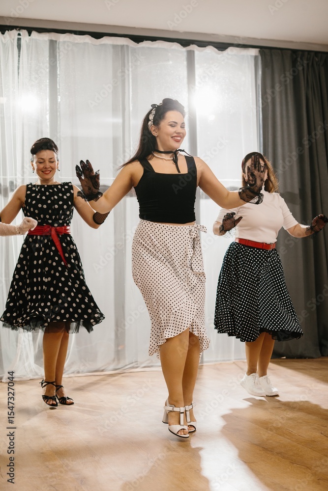 Naklejka premium Pinup dancers wearing polka dots swing dancing together