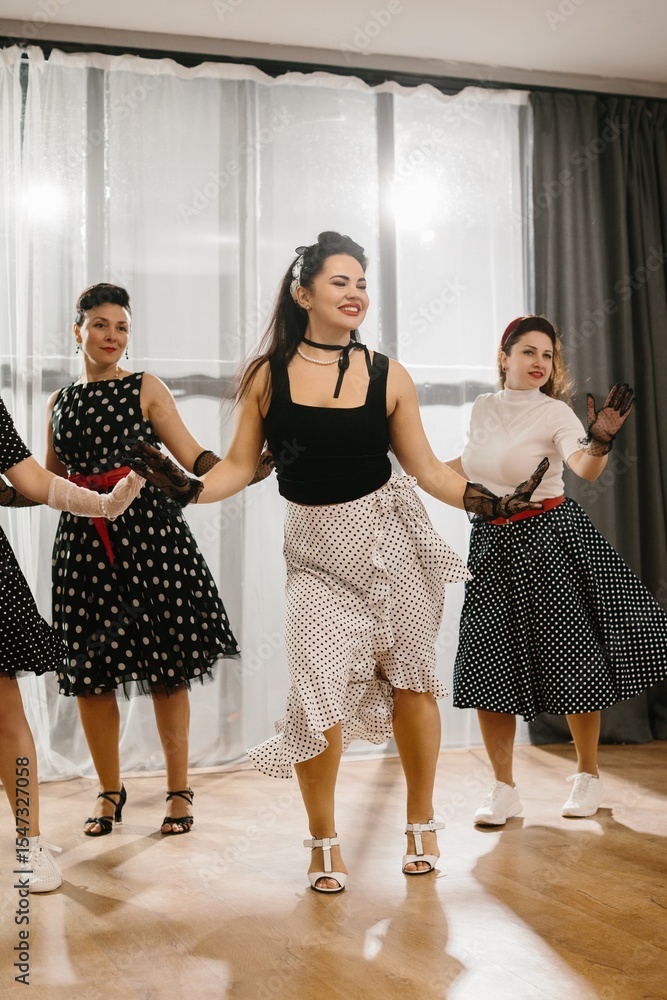 Naklejka premium Women wearing polka dot dresses and dancing rock and roll or lindy hop