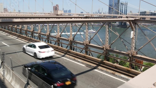 Cars on Brooklyn Bridge, New York City Manhattan Bridge and Midtown view. Yellow taxi cab, Road traffic and architecture. Iconic landmark on East River. Travel USA.