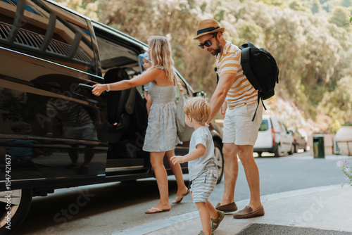 Tableau sur toile Parents with toddlers boarding car for airport transfer or holiday trip