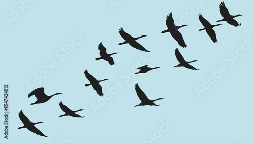 A flock of black silhouette geese flying in a classic V-formation against a clear light blue sky, showcasing the migration and natural wildlife beauty.