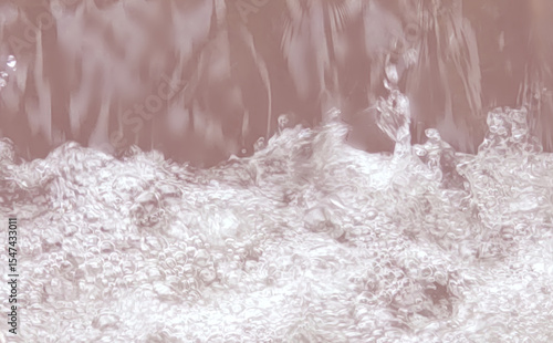 ピンク色の川面に落ちる水しぶきの写真