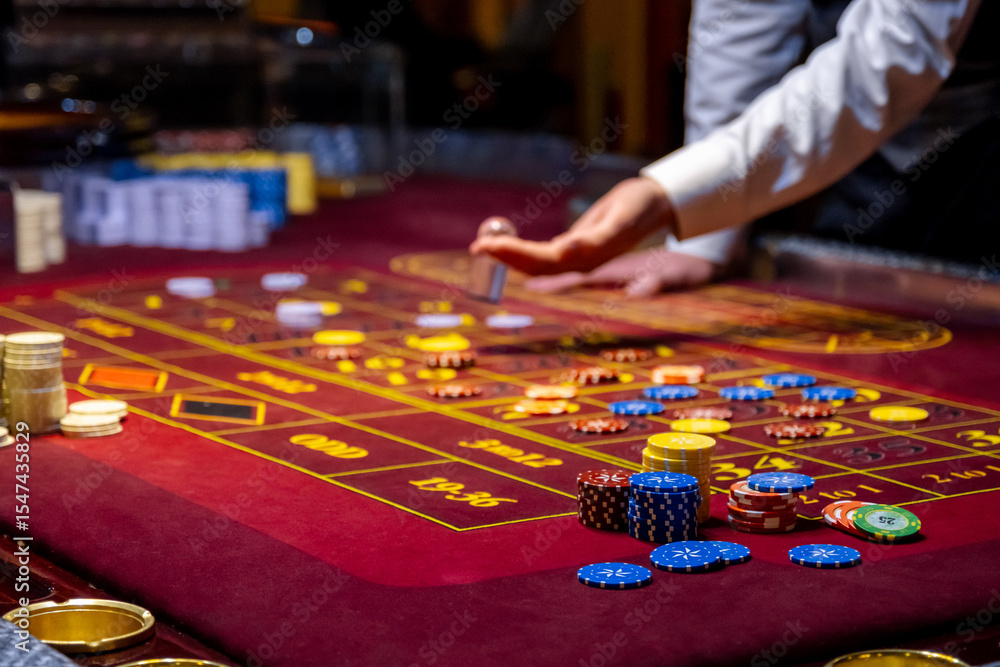 Close up of a Roulette Table. People play poker in the casino. Croupier behind gambling table in a casino Close up of a Roulette Table. People play poker in the casino. Croupier behind gambling table in a casino