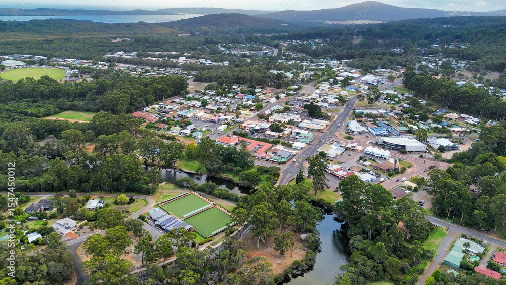 Fototapeta premium Aerial image of Small rural town, Denmark Western Australia captured from above showing the river, bowling green, main roads, buildings. The background has beautiful landscape with hills and water 