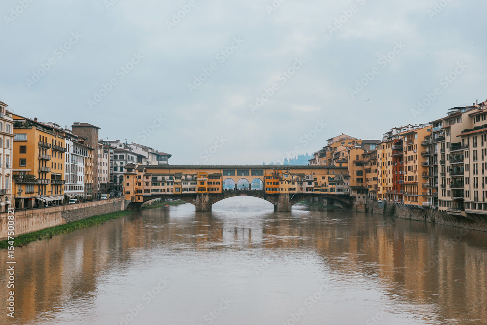Fototapeta premium ponte vecchio florence italy with water reflections and cloudy sky