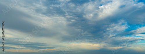 Background with calm blue sky and white cumulus clouds. Relaxing backdrop on the theme of weather and climate.