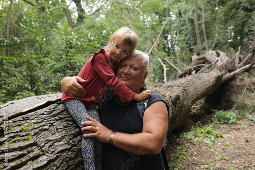 Grandfather and granddaughter share a warm embrace during a hike in the forest. A touching moment of love, bonding, and family adventure in the heart of nature