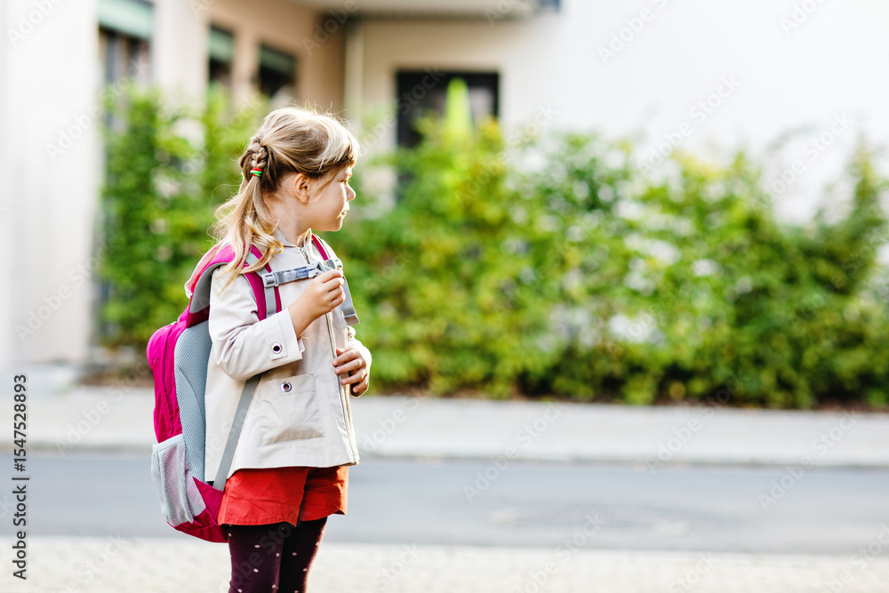 Naklejka premium Cute little preschool girl going to playschool. Healthy toddler child walking to nursery school and kindergarten. Happy child with backpack on the city street, outdoors.