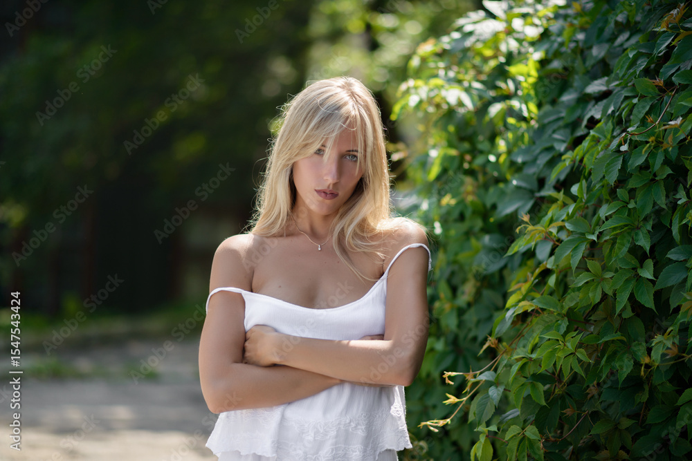 Outdoor portrait of beautiful young woman with green eyes at summertime. Outdoor portrait of beautiful young woman with green eyes at summertime.
