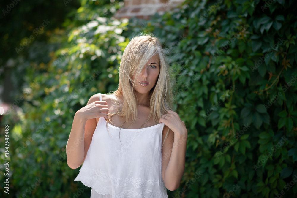 Outdoor portrait of beautiful young woman with green eyes at summertime. Outdoor portrait of beautiful young woman with green eyes at summertime.