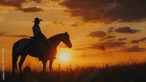 Silhouette of a cowboy on a horse against the sunset sky, during the golden hour. A wild west scene.