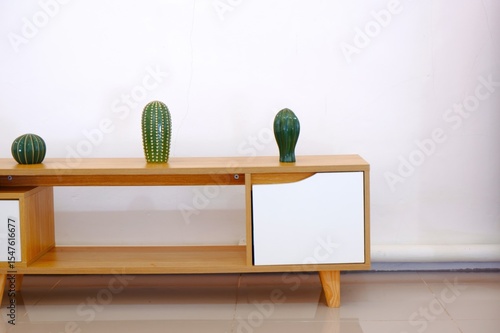 Minimalist Green Cacti on Light Brown Wooden Shelf Against White Wall