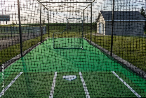 a close up of baseball batting cage on the first base side of the field