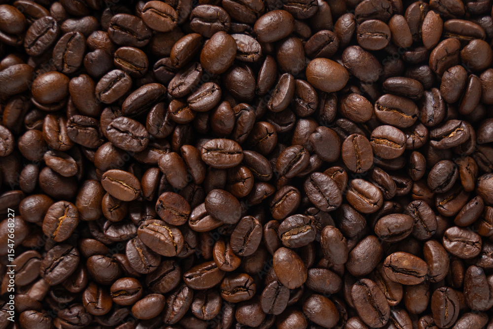 Roasted coffee beans background. Top view of dark brown coffee beans. Close up image. Roasted coffee beans background. Top view of dark brown coffee beans. Close up image.