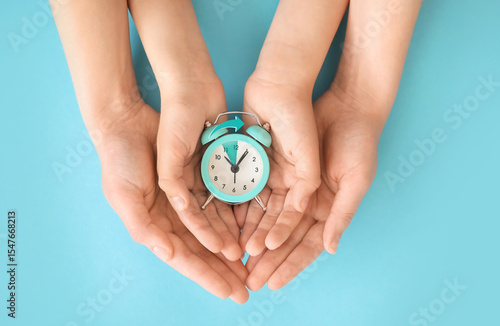 Hands of family with alarm ...