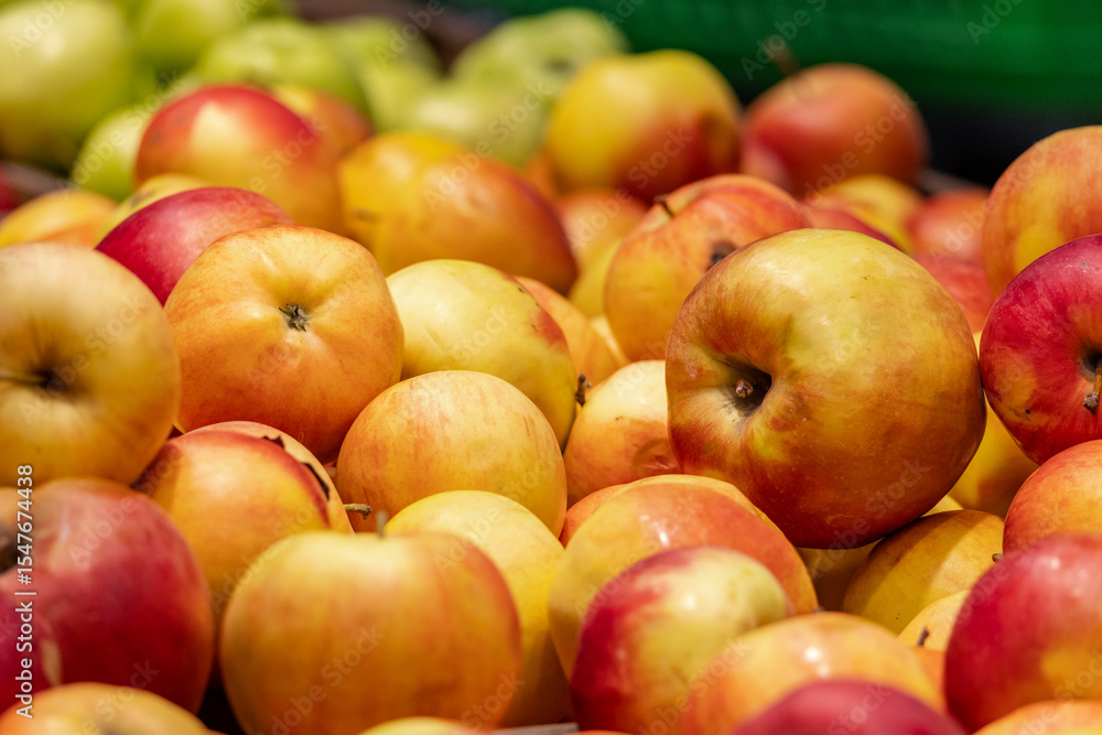 Red apples on display at bright grocery store aisle. Closeup shot of fresh red and yellow apples Red apples on display at bright grocery store aisle. Closeup shot of fresh red and yellow apples