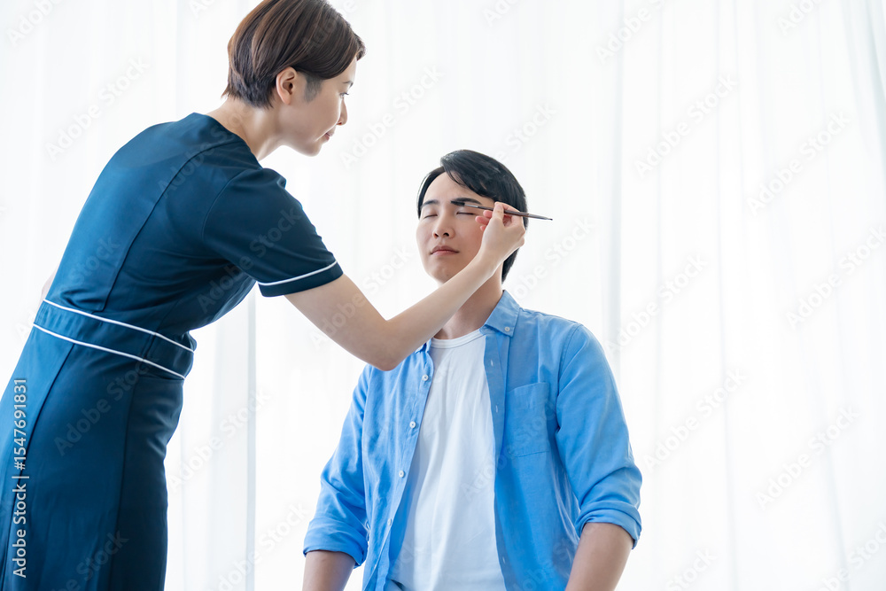 Obraz premium 眉毛を描いてもらう男性