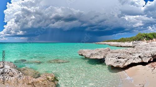 Turquoise sea rocky coast and dramatic storm clouds Clear water laps a sandy beach