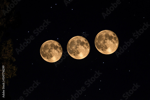 Three full moons shining brightly in a starry night sky
