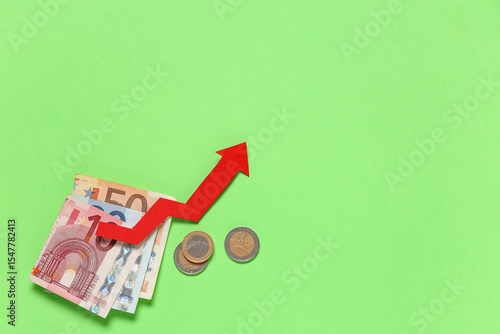 Money with red arrow on gre...