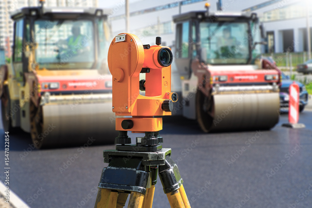 Surveyor device. Road construction. Geodetic measurement during asphalt laying. Geodetic control. Asphalt pavers build road. Surveyor device for creating level road surface. Art focus Surveyor device. Road construction. Geodetic measurement during asphalt laying. Geodetic control. Asphalt pavers build road. Surveyor device for creating level road surface. Art focus