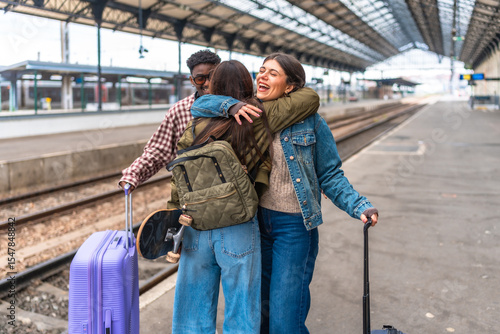 Happy friends hugging at train station after long journey