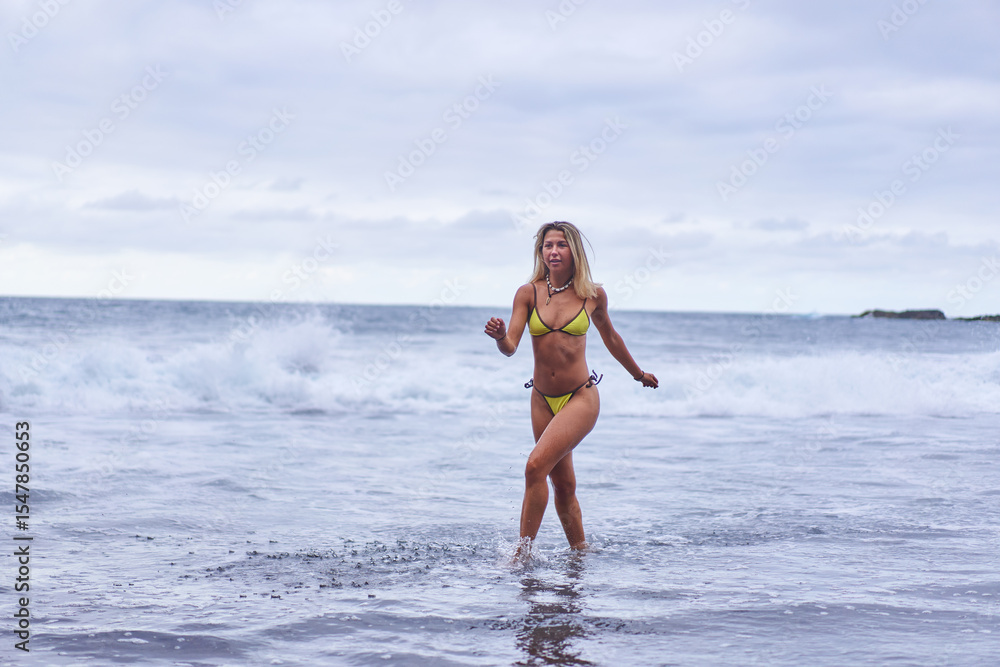 Fototapeta premium Bikini model posing on volcanic beach