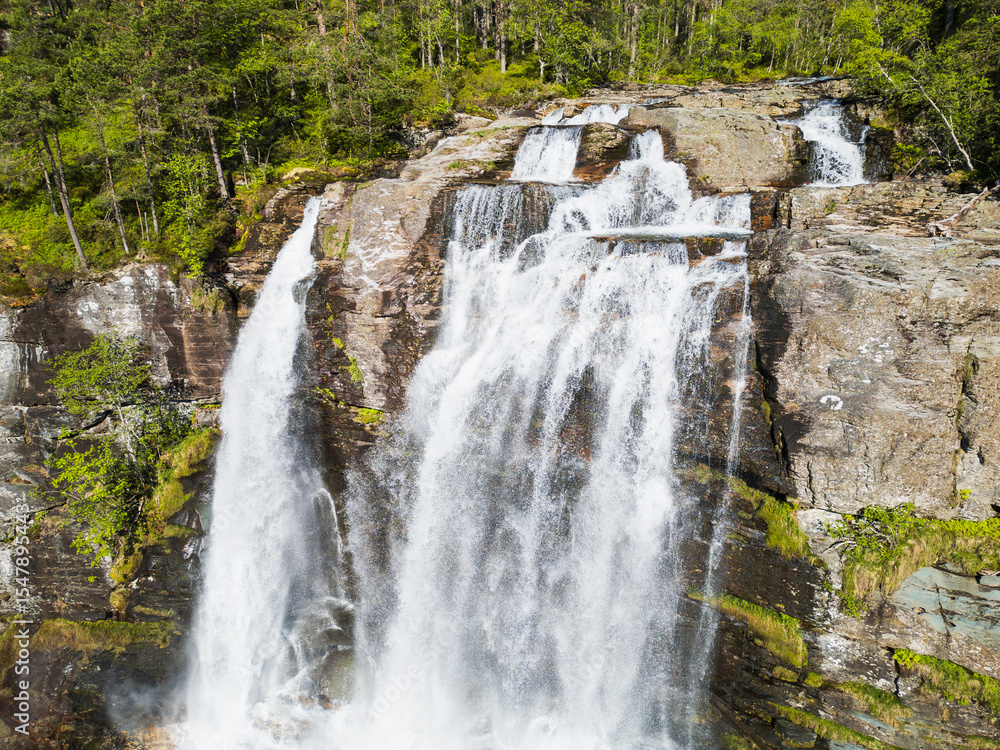 Fototapeta premium An aerial view of the upper part of the famous Svandalsfossen waterfall in Norway: a turbulent stream of water forces its way through the rocky riverbed before the main drop.