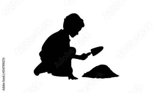 A simple black silhouette of a child crouched down, playing with a small shovel in the sand.