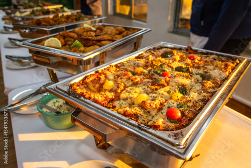Vegetable lasagna in a metal dish at a buffet 