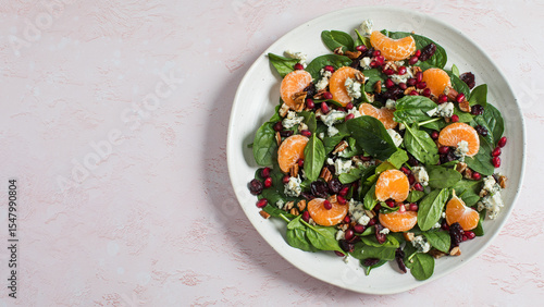 Fresh spinach and citrus salad with pomegranate and blue cheese for healthy eating. Copy space