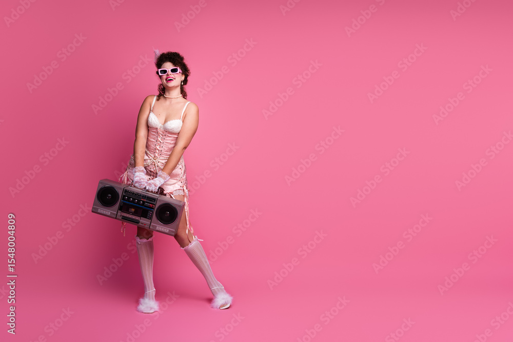 Fototapeta premium A young woman in elegant vintage attire poses against a vibrant pink background, embracing a blend of past and present styles