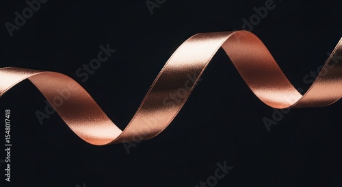 Rose gold ribbon in a graceful spiral against a black background.