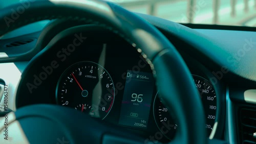 Car speedometer in ECO mode for reduced emissions showing rising speed and current gear. Dashboard indicating fuel range, engine RPM, and temperature. Digital display presenting driving data with