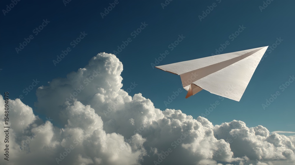 Fototapeta premium A paper airplane soars through a vibrant blue sky filled with clouds.