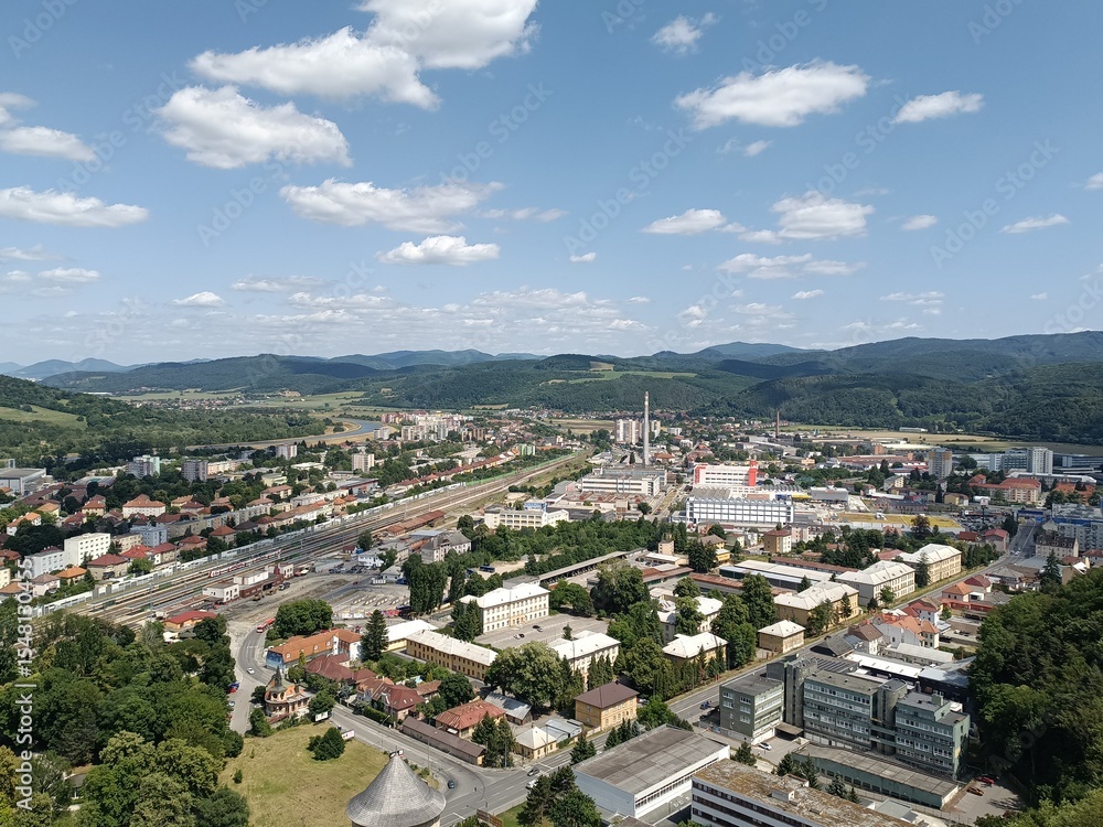 Fototapeta premium A panoramic view of trencin slovakia featuring its historic cityscape, river, and surrounding hills under a blue sky, concept of european tourism, urban landscape, historical architecture
