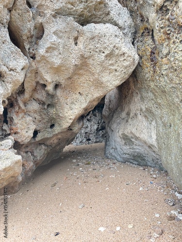 Coastal Cave Entrance: Explore a natural coastal cave carved by the elements, revealing a sandy pathway and captivating textures, a testament to nature's enduring artistry.