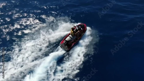 Person riding a red jetski on the blue ocean