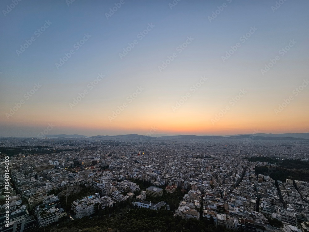 Fototapeta premium Sunset in Athens with a view of the mountains and the setting sun