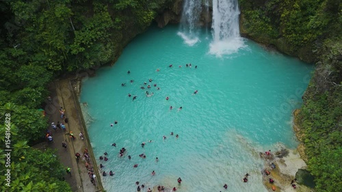 Aerial Drone Shot of Kawasan Falls with Tourists Swimming in Crystal Clear Blue Water Amidst a Jungle Oasis in Cebu, Philippines