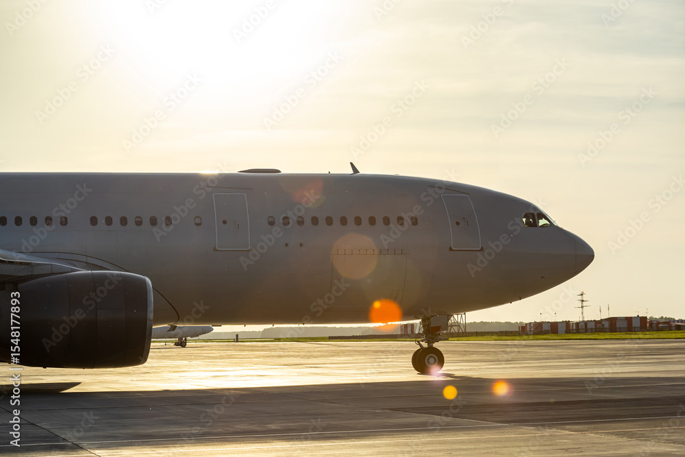 Obraz premium Close-up of wide body airplane at airport in morning sunlight