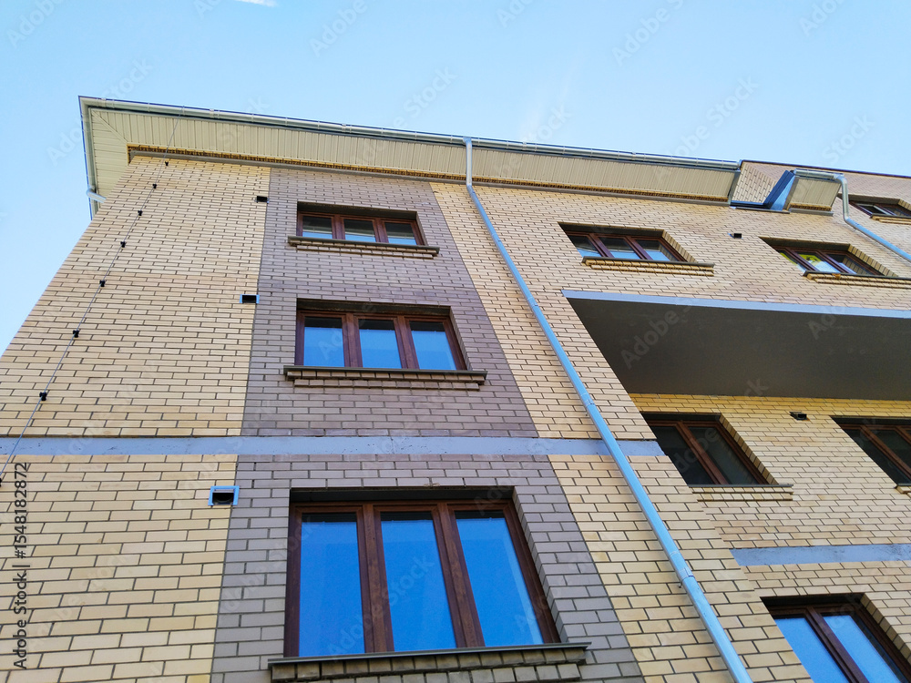 Obraz premium Facade of new multi-story building. Sale and rental apartments. Housing affordability and development. Cityscape. City living. Commercial Real estate investing. Mortgage concept. developer. Window.